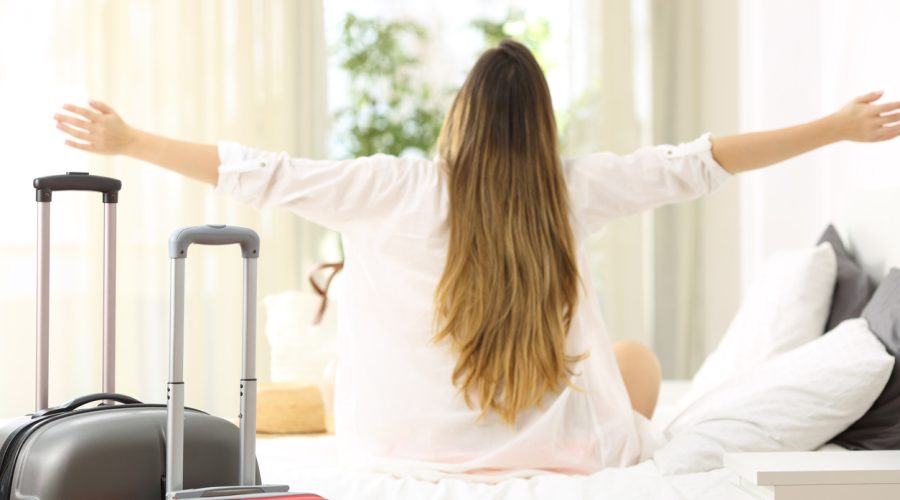 Traveler celebrating vacations in an hotel room